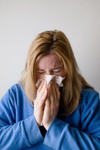 woman sneezing after bird contact possible allergy